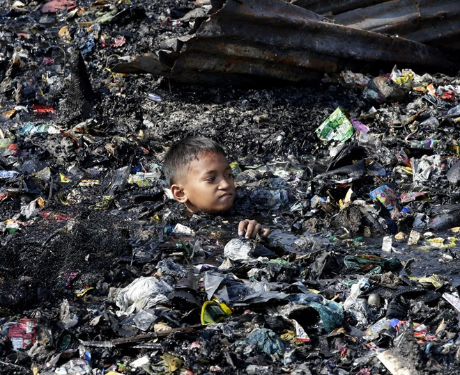 Cậu bé ngụp lặn trong một đống đổ nát là hiện trường của một vụ hỏa hoạn lớn nuốt chửng khu dân cư tự phát ở thành phố Malabon, phía bắc thủ đô Manila, Philippines, hôm 10/12. Ngọn lửa thiêu rụi hơn 200 ngôi nhà, ảnh hưởng cuộc sống của ít nhất 1.000 người. Cảnh sát đang điều tra nguyên nhân vụ hỏa hoạn. Ảnh: AP Những cậu bé ngụp lặn trong một đống đổ nát là hiện trường của một vụ hỏa hoạn lớn, nuốt chửng khu dân cư tự phát ở thành phố Malabon, phía bắc thủ đô Manila, Philippines. Ngọn lửa thiêu rụi hơn 200 ngôi nhà, ảnh hưởng cuộc sống của ít nhất 1.000 người. Cảnh sát đang điều tra nguyên nhân vụ hỏa hoạn. Ảnh: AP