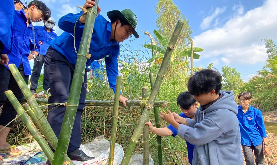 Thầy Võ Ngọc Bia (đội nón tai bèo) cùng đoàn viên thực hiện công trình chống sạt lở “Bờ tre xanh”.