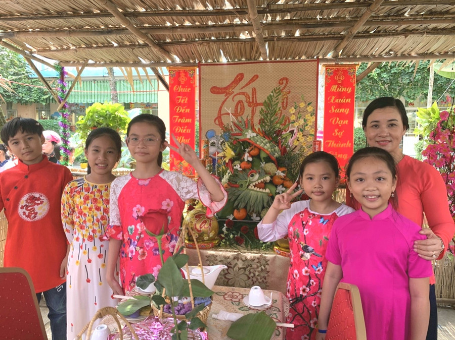 Giáo viên và học sinh chụp hình lưu niệm bên mâm cỗ ngày xuân.