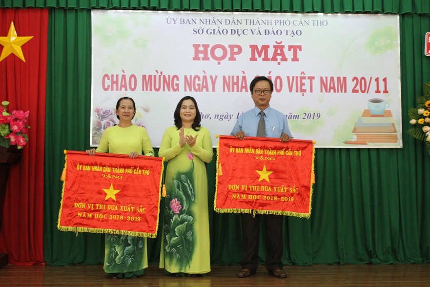 Bà Trần Hồng Thắm - Giám đốc Sở GD&ĐT TP Cần Thơ trao Cờ thi đua của UBND TP Cần Thơ cho 2 tập thể.