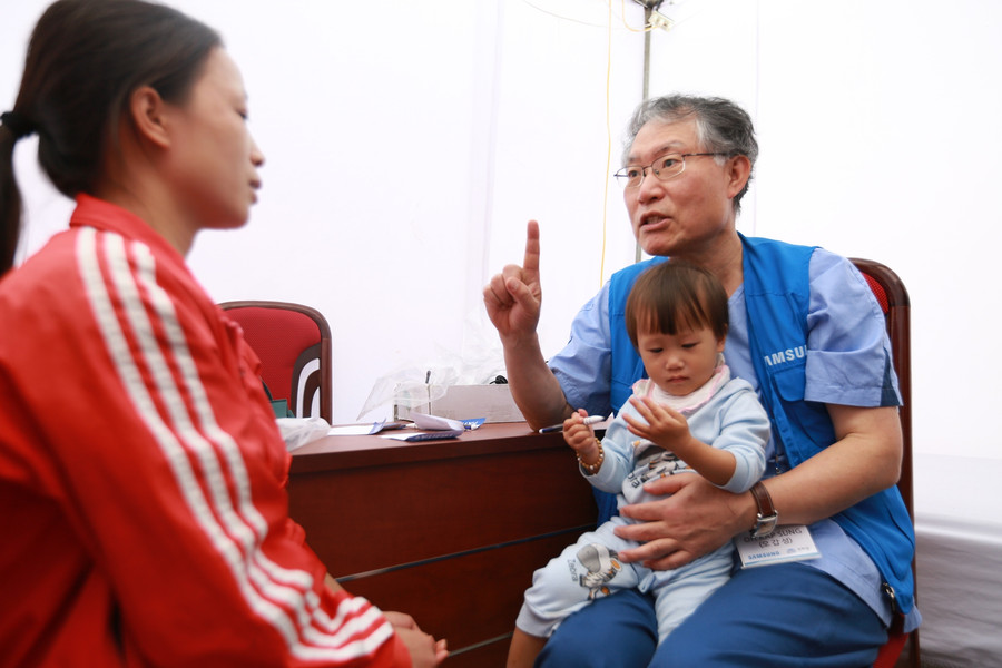 Giáo sư phẫu thuật Oh Kapsung khám bệnh cho bệnh nhi bị dính ngón tay