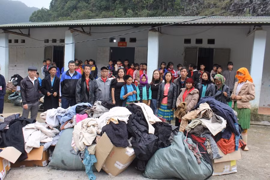 Các thành viên trong đoàn từ thiện chụp ảnh lưu niệm trao áo ấm cho các em học sinh khó khăn và đồng bào dân tộc Mông thuộc diện hộ nghèo của xã Giàng Chu Phìn, huyện Mèo Vạc.