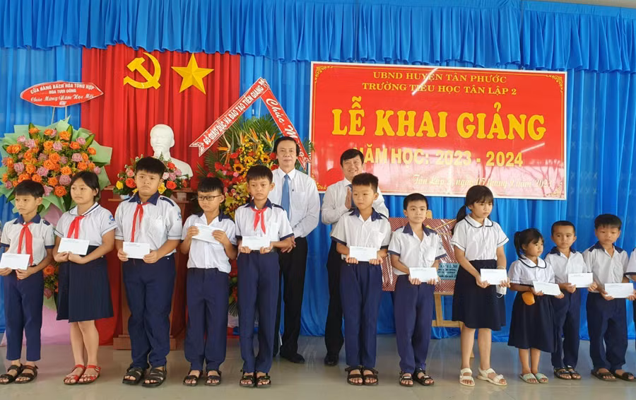Ông Nguyễn Văn Danh - Bí thư Tỉnh ủy và ông Lê Quang Trí - Giám đốc Sở GD&amp;ĐT Tiền Giang trao học bổng cho học sinh Trường TH Tân Lập 2, huyện Tân Phước dịp khai giảng.