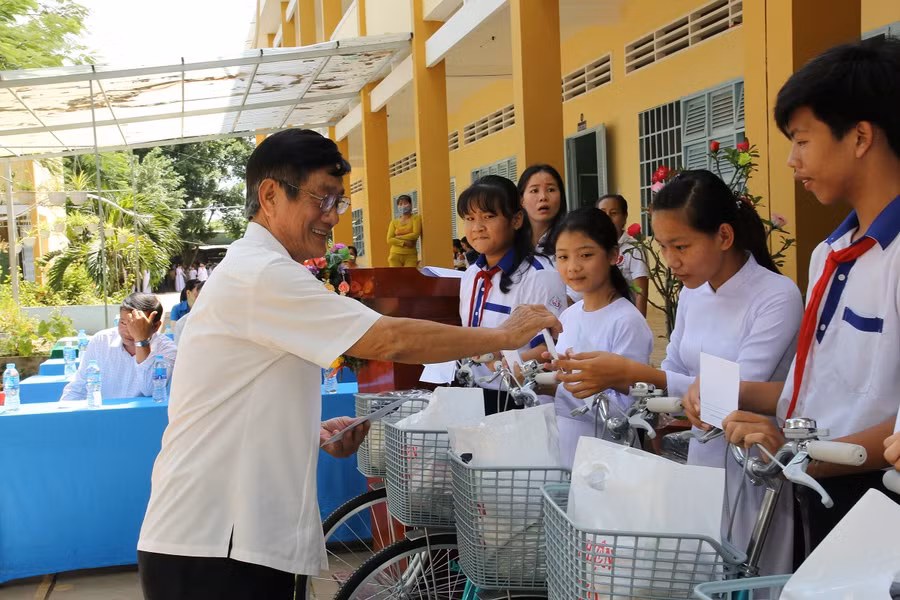 Giám đốc Sở LĐ,TB&amp;XH Phạm Minh Trí trao quà cho HS.
