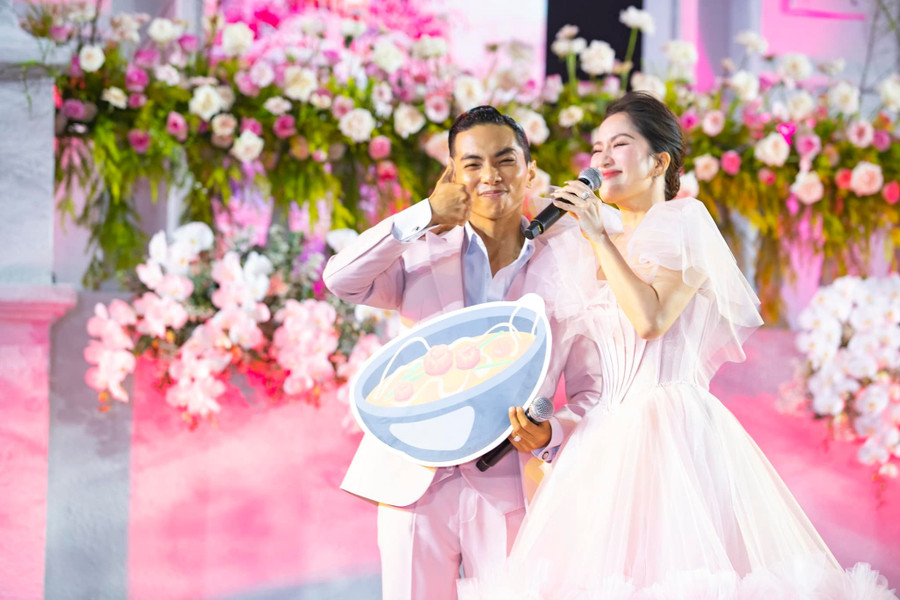 Khánh Thi diện chiếc váy cô dâu tông màu hồng vô cùng ngọt ngào được biến tấu cách điệu, không quá dài và ôm sát cơ thể. Chiếc váy này vừa tôn lên vẻ đẹp dịu dàng của Khánh Thi vừa giúp cô có thể &quot;quẩy&quot; hết mình cùng bạn bè trong tiệc cưới.