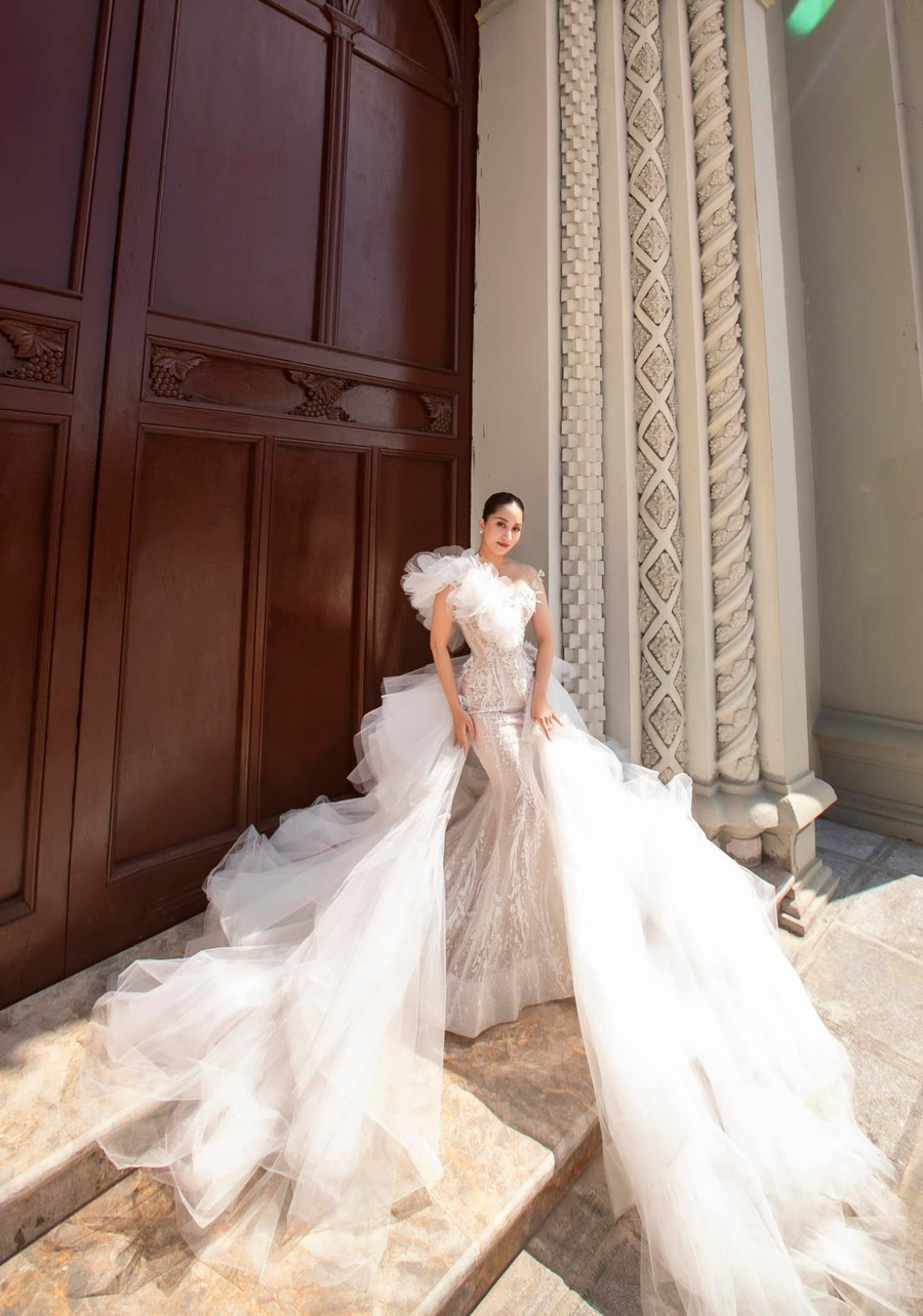 Trong một bộ ảnh cưới khác, Khánh Thi đã cho mọi người thấy sự đa dạng trong phong cách của mình. Lần này cô lựa chọn chiếc váy cưới ôm sát cơ thể, cùng vạt váy dài vô cùng ấn tượng và quyến rũ.