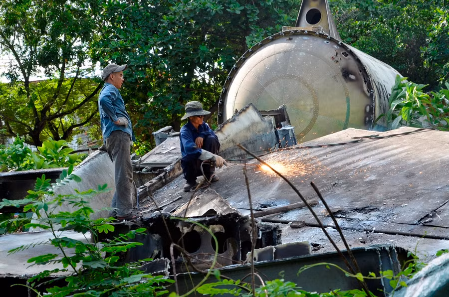 Nhóm công nhân thay phiên nhau cắt rời phần bụng chiếc máy bay