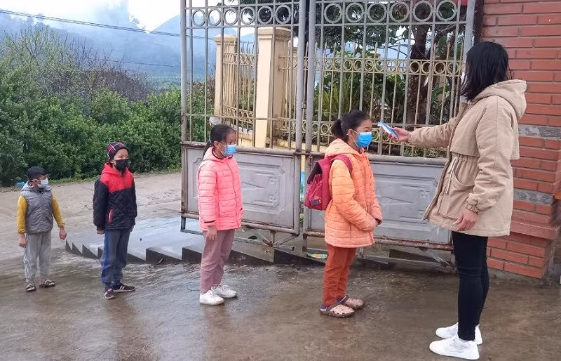 Học sinh Trường PTDTBT Tiểu học Nậm Chảy (Mường Khương, Lào Cai) được đo thân nhiệt và thực hiện 5K trước khi vào lớp. Ảnh: NTCC
