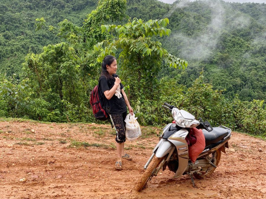 Đường dốc trơn trượt, cô Vi Thị Đông không thể đi xe máy mà phải dắt bộ vào điểm trường.