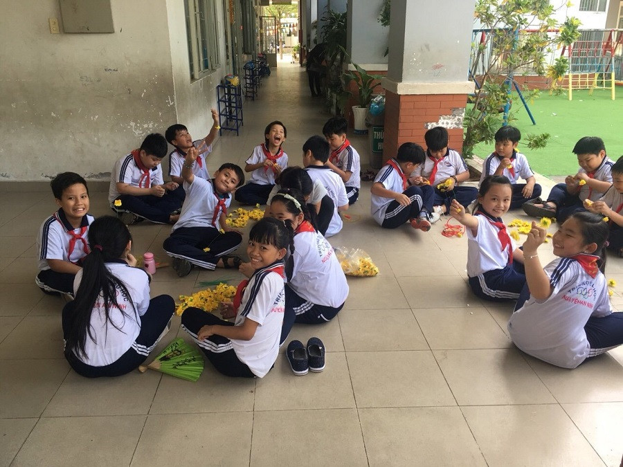 Các em học sinh tham gia hỗ trợ làm cành mai.