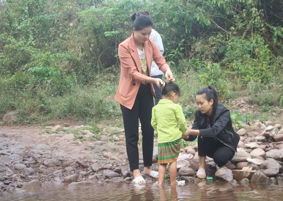 Cầm Thị Kim (trái) và Lò Thị Liệu( phải) rửa mặt, cột tóc trước khi cõng học sinh đến trường