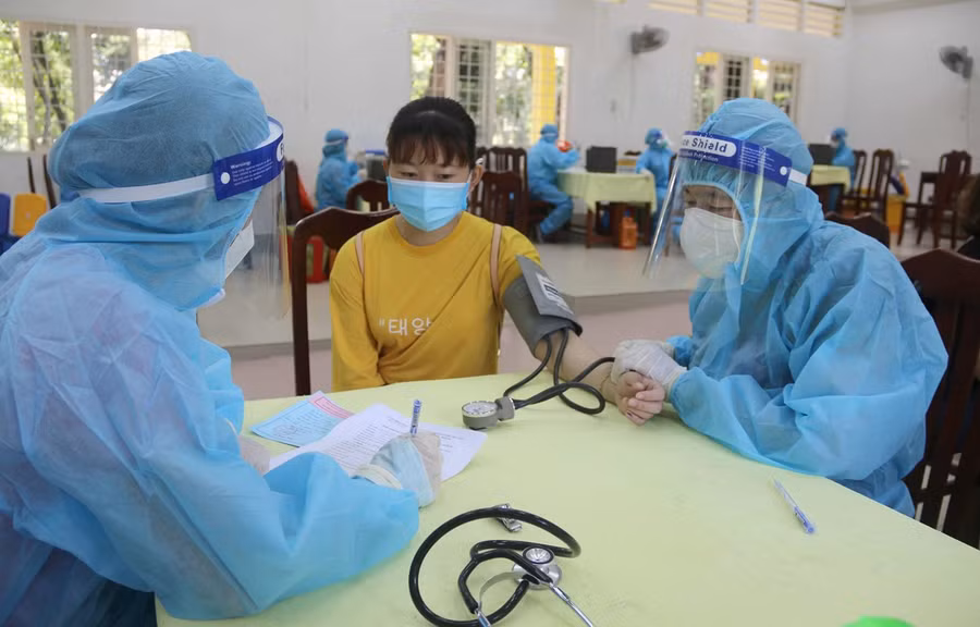 Khám sàng lọc trước khi tiêm vaccine tại điểm tiêm trường Đại học Trà Vinh. (Ảnh: Thanh Hòa/TTXVN)