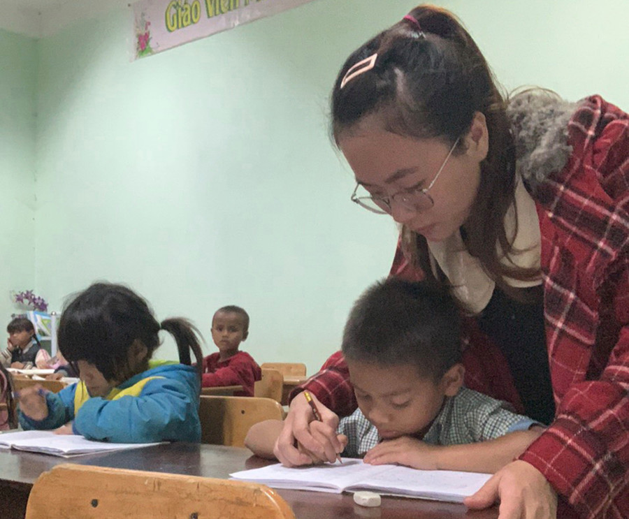 GV luyện chữ cho HS trong giờ học tình nguyện buổi tối.