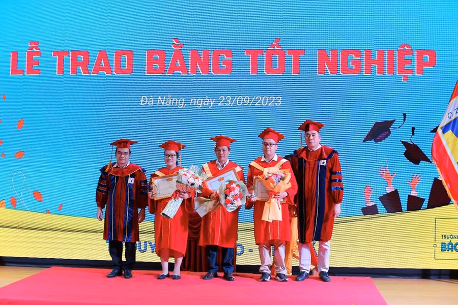 Đại diện Trường ĐH Bách khoa, ĐH Đà Nẵng trao bằng khen và tặng hoa cho các tân Thạc sĩ đạt danh hiệu thủ khoa. 