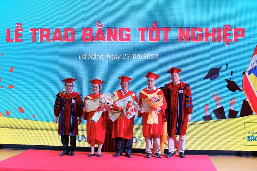 Đại diện Trường ĐH Bách khoa, ĐH Đà Nẵng trao bằng khen và tặng hoa cho các tân Thạc sĩ đạt danh hiệu thủ khoa. 