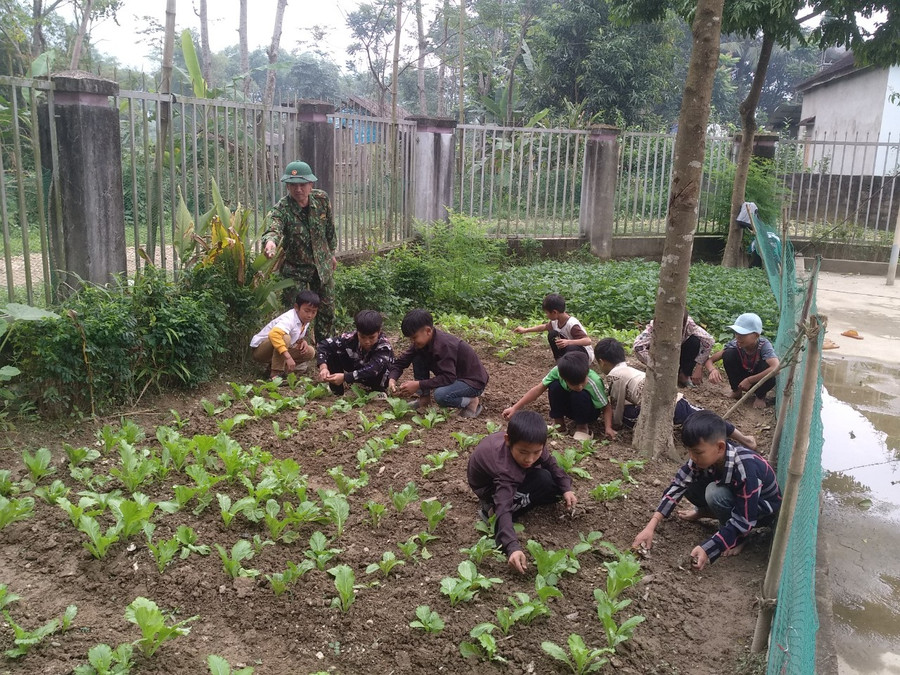 Bộ đội Biên phòng Đồn Biên phòng Môn Sơn hướng dẫn học sinh trồng rau, tăng gia sản xuất. Ảnh: NVCC