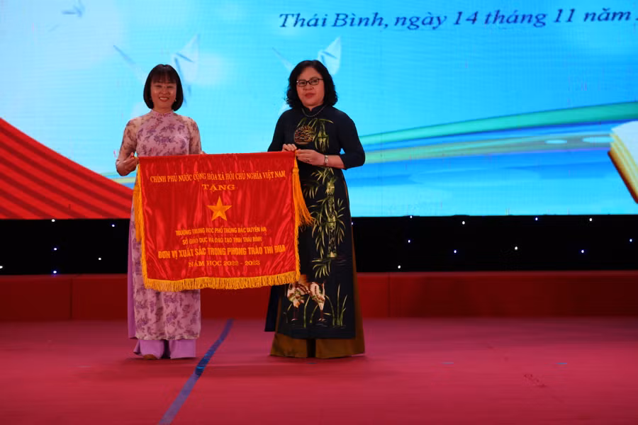 Thứ trưởng Bộ GD&amp;ĐT Ngô Thị Minh trao Cờ thi đua của Chính phủ cho đại diện Trường THPT Bắc Duyên Hà.