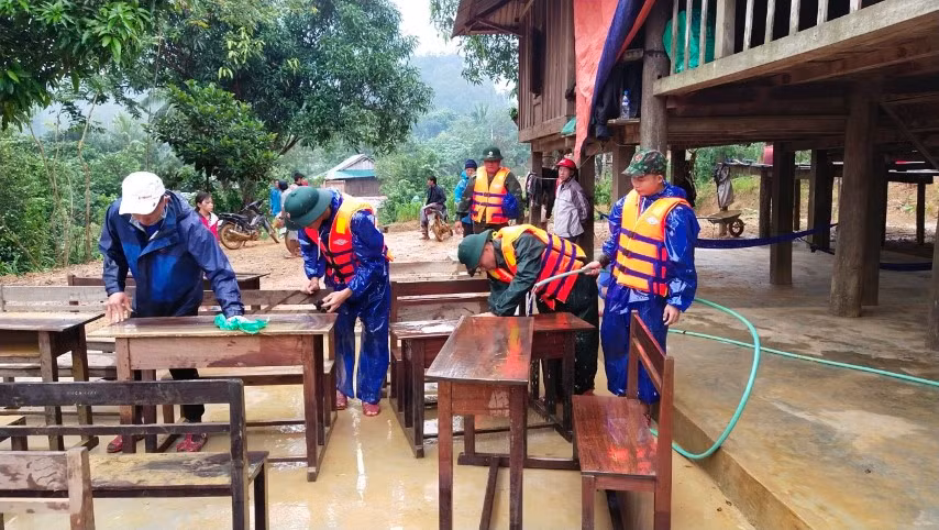 Cán bộ chiến sĩ Biên phòng lau chùi bàn ghế học sinh sau lũ tại xã Trường Sơn (Quảng Ninh, Quảng Bình).