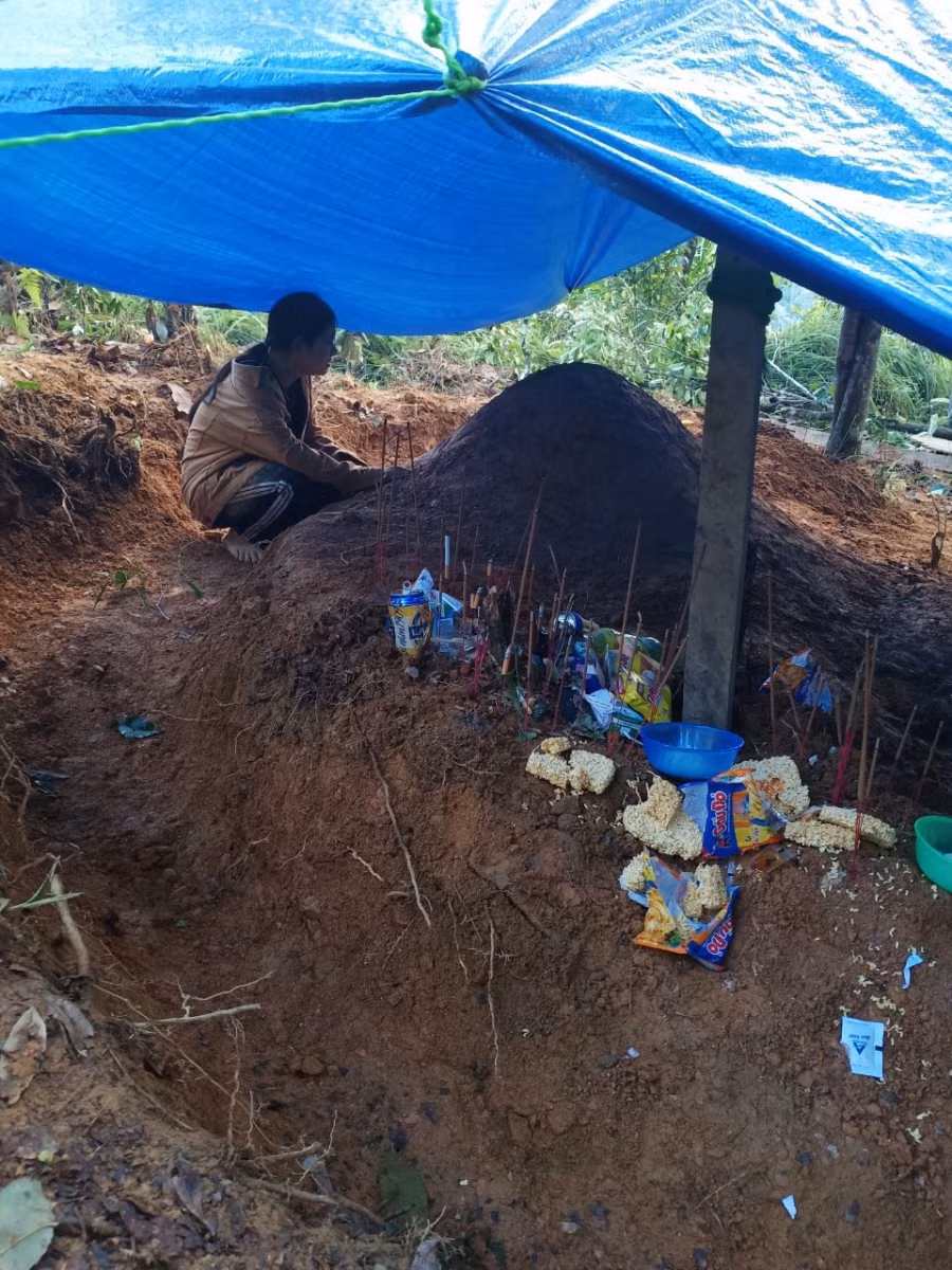 Em Đinh Thị Điệp - HS trường THPT Nam Trà My bên nấm mồ cha mẹ được người dân lập vội sau vụ sạt lở kinh hoàng ở Trà Leng