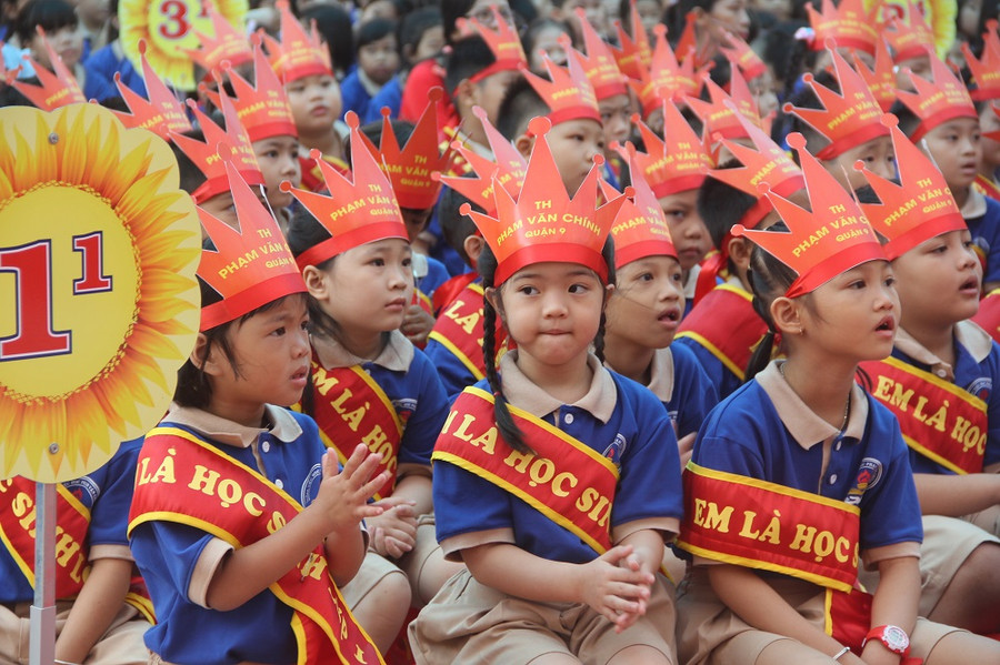 Học sinh lớp 1 chăm chú lắng nghe những tiết mục văn nghệ trong lễ khai giảng.
