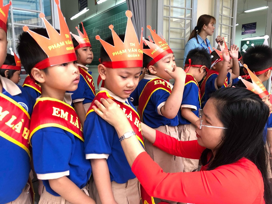 Cô giáo chỉnh lại trang phục cho trò để chuẩn bị cho nghi thức đón học sinh lớp 1.