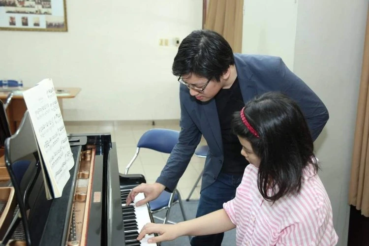 Giảng viên Nhạc viện hướng dẫn thí sinh luyện tập đàn Piano tại Hội thi Tài năng âm nhạc do Nhạc viện TPHCM tổ chức. Ảnh: NTCC