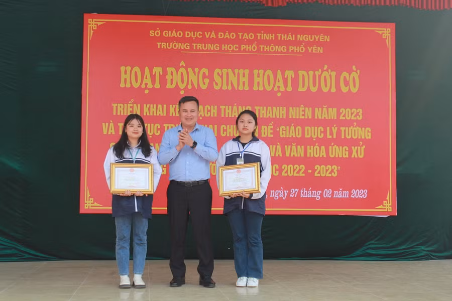 Ông Trần Văn Thiện, Phó Chủ tịch UBND thành phố Phổ Yên trao giấy khen và tiền thưởng cho hai em Ngô Thị Dung và Mai Thị Thanh Nga, lớp 11B3, trường THPT Phổ Yên.