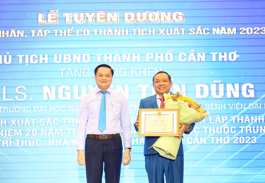 Ông Dương Tấn Hiển - Phó Chủ tịch thường trực UBND TP Cần Thơ trao Bằng khen của Chủ tịch UBND TP Cần Thơ cho Tiến sĩ, Luật sư Nguyễn Tiến Dũng - Chủ tịch Hội đồng Trường ĐH Nam Cần Thơ.