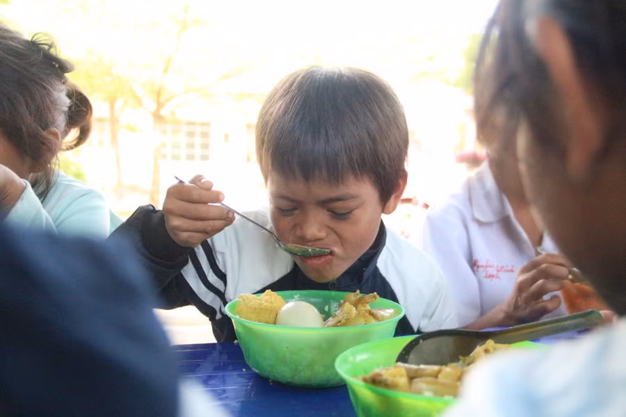 Học sinh thưởng thức cơm trưa sau giờ học buổi sáng.