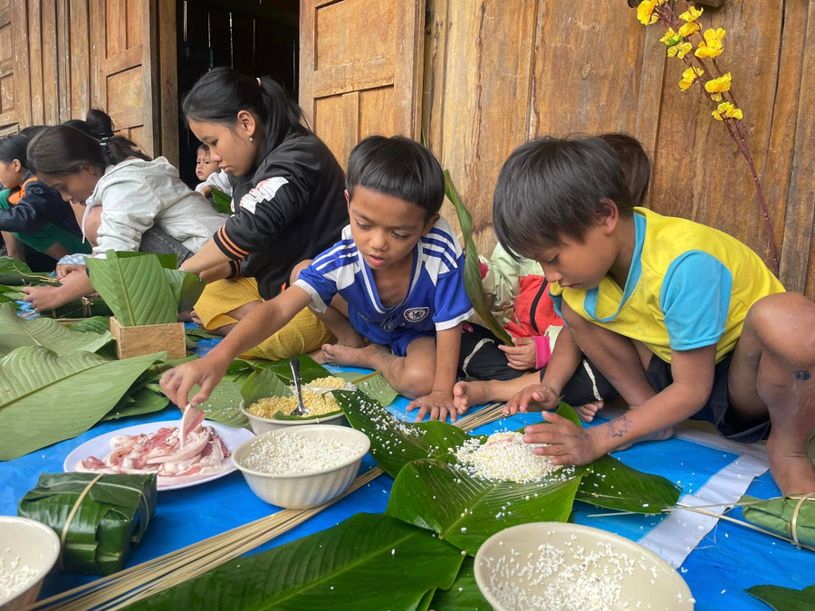 Học sinh điểm trường Lang Lương (Trường Phổ thông dân tộc bán trú Tiểu học Trà Tập, Nam Trà My, Quảng Nam) trải nghiệm gói bánh chưng. (Ảnh: Trà Thu) Học sinh điểm trường Lang Lương (Trường Phổ thông dân tộc bán trú Tiểu học Trà Tập, Nam Trà My, Quảng Nam) trải nghiệm gói bánh chưng. (Ảnh: Trà Thu)