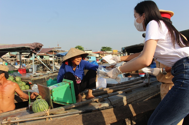 Hoa khôi Thuý Vi - Người đẹp Du lịch TP Cần Thơ phát khẩu trang cho người dân Chợ nổi Cái Răng.