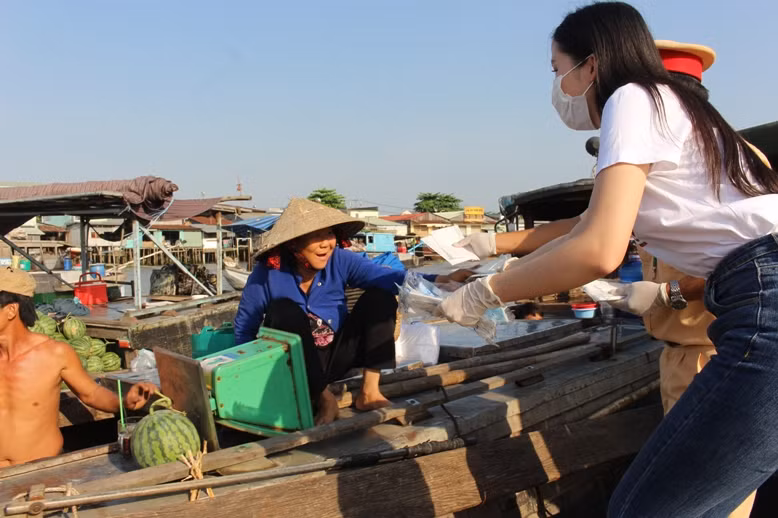 Hoa khôi Thuý Vi - Người đẹp Du lịch TP Cần Thơ phát khẩu trang cho người dân Chợ nổi Cái Răng.