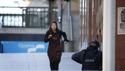 Elly Chen - Nhân viên quán cafe Lindt - chạy khỏi quán qua cửa trước. Ảnh: Reuters