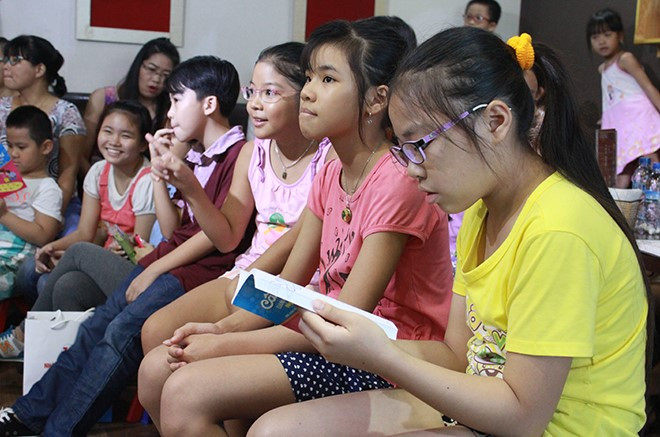 Các em nhỏ rất hứng thú với các câu hỏi và sách do thầy giáo viết bằng chân Nguyễn Ngọc Ký viết ra Các em nhỏ rất hứng thú với các câu hỏi và sách do thầy giáo viết bằng chân Nguyễn Ngọc Ký viết ra