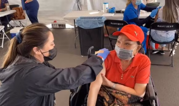 Nghệ sĩ cải lương Hồng Nga đi tiêm vắc xin.