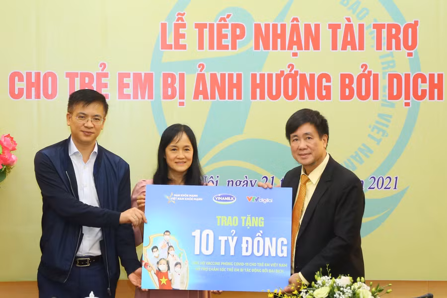 Ông Hoàng Văn Tiến (bìa phải ảnh) tiếp nhận tài trợ cho trẻ em bị ảnh hưởng bởi dịch Covid-19 của Công ty CP sữa Việt Nam (Vinamilk)