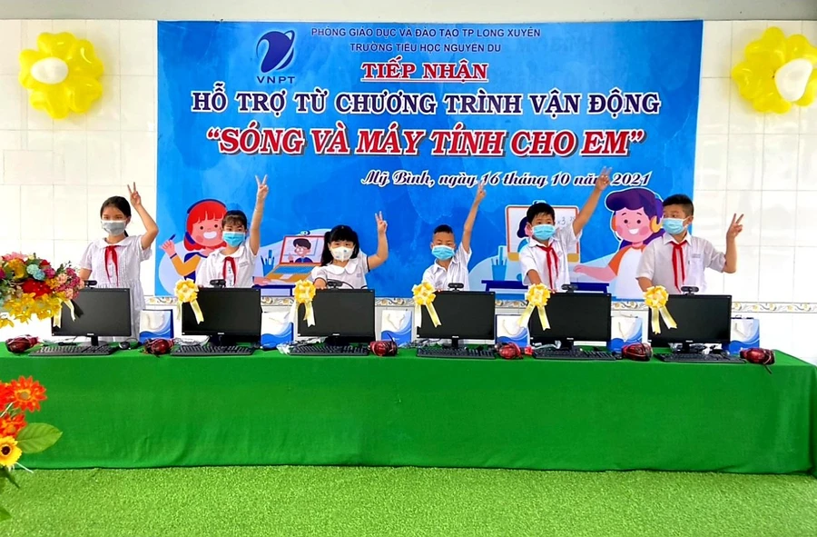 Niềm vui của các em HS khi được trao tặng bộ máy tính để học trực tuyến.