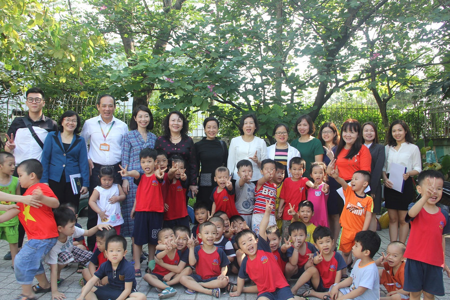 Đoàn công tác chụp hình lưu niệm với ban giám đốc, ban giám hiệu nhà trường và các trẻ ở Trường MN Mặt trời nhỏ