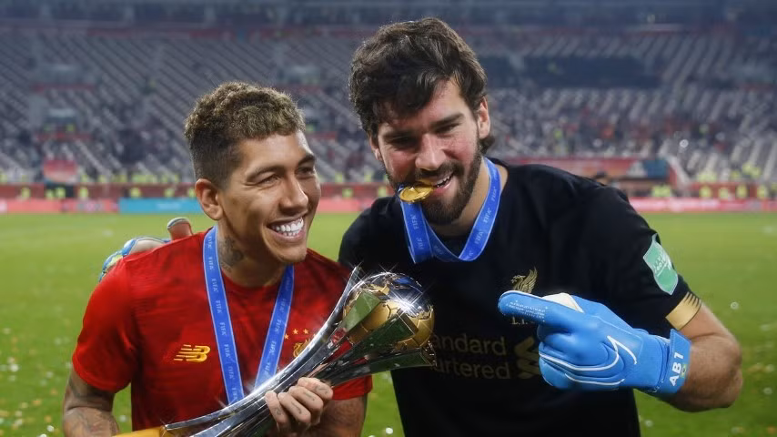 Tiền vệ Roberto Firmino (bên trái) và thủ môn Alisson trong màu áo Liverpool.