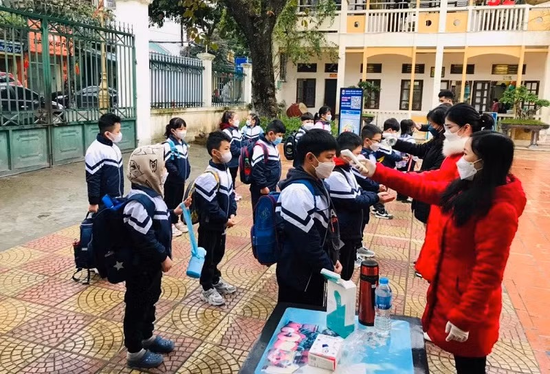 Giáo viên và học sinh Trường Tiểu học Trần Phú (Sơn Tây, Hà Nội) kiểm soát dịch từ cổng trường. Ảnh: NTCC