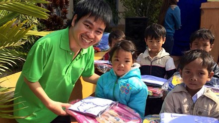 Cử nhân khuyết tật và 5.000 suất cơm yêu thương ảnh 1 Anh Nguyễn Duy Học trao cặp, áo cho trẻ em trong chương trình “Vì trẻ em nghèo”. Ảnh: L.H.