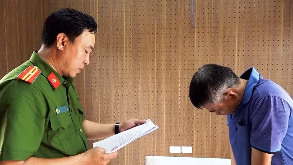 Công an tống đạt các quyết định và lệnh tạm giam đối với bị can Trường (Ảnh: Tiến Tầm)