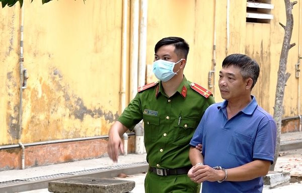 Lực lượng chức năng áp giải Lê Văn Trường về nơi tạm giam (Ảnh: Tiến Tầm)