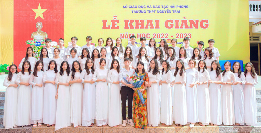 Trương Tuấn Minh chụp hình lưu niệm cùng cô giáo chủ nhiệm và tập thể lớp 12A6, Trường THPT Nguyễn Trãi.