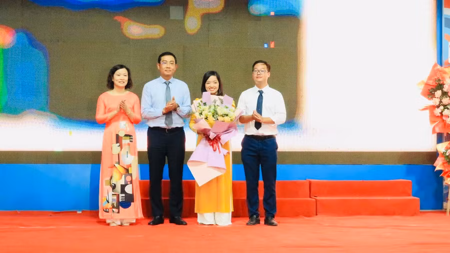 Ông Bùi Văn Kiệm, Giám đốc Sở GD&amp;ĐT Hải Phòng (áo xanh) tặng hoa chúc mừng.