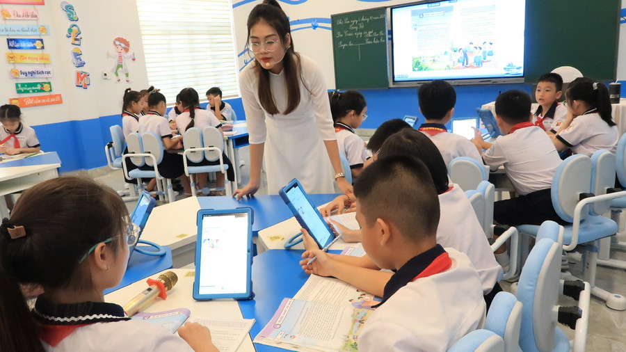 Giáo viên kiểm tra hoạt động nhóm của học sinh.