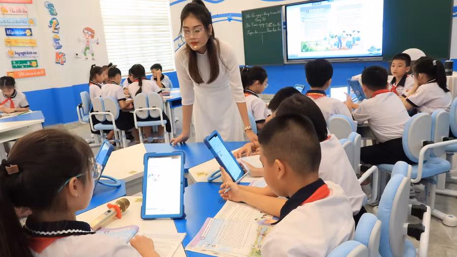 Giáo viên kiểm tra hoạt động nhóm của học sinh.