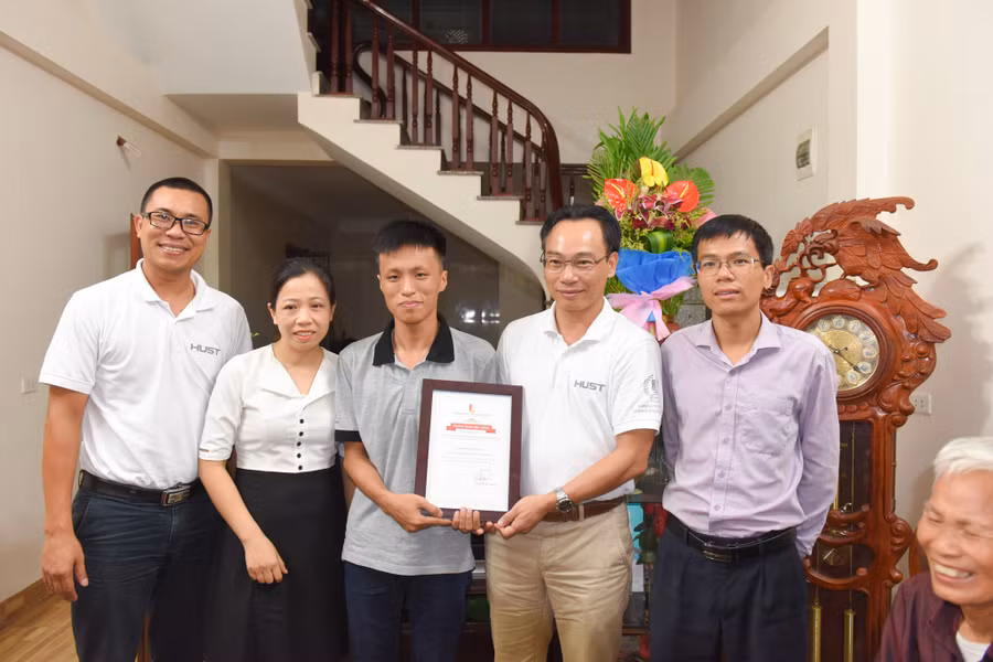 Ông Hoàng Minh Sơn - Hiệu trưởng Trường ĐH Bách khoa Hà Nội trao suất học bổng trị giá 150% học phí cho thủ khoa khối A cả nước Vương Xuân Hoàng. Cô giáo chủ nhiệm của Hoàng cũng chứng kiến, chia vui với thành tích của học trò