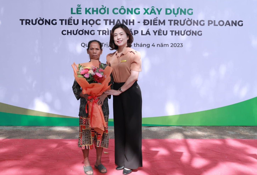Bà Nguyễn Thanh Nga - Trưởng phòng GD&amp;ĐT huyện Hướng Hóa tặng hoa biểu dương bà Hồ Thị Nuông.