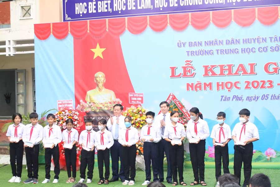 Trưởng Ban Tuyên giáo Trung ương Nguyễn Trọng Nghĩa trao học bổng cho học sinh.